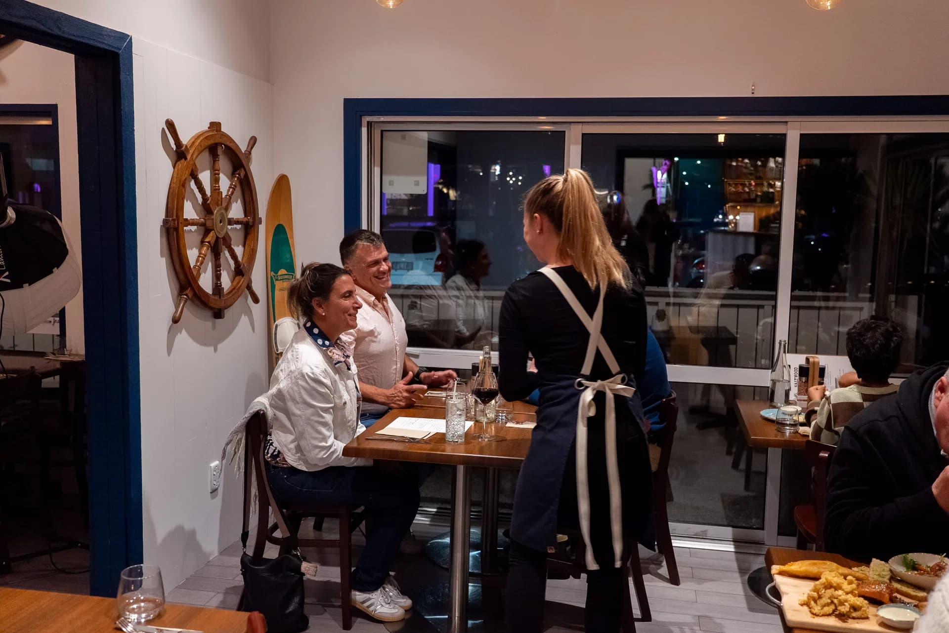 Guests being served at a candlelit table in Saltwood's nautical dining room, Ferrymead.