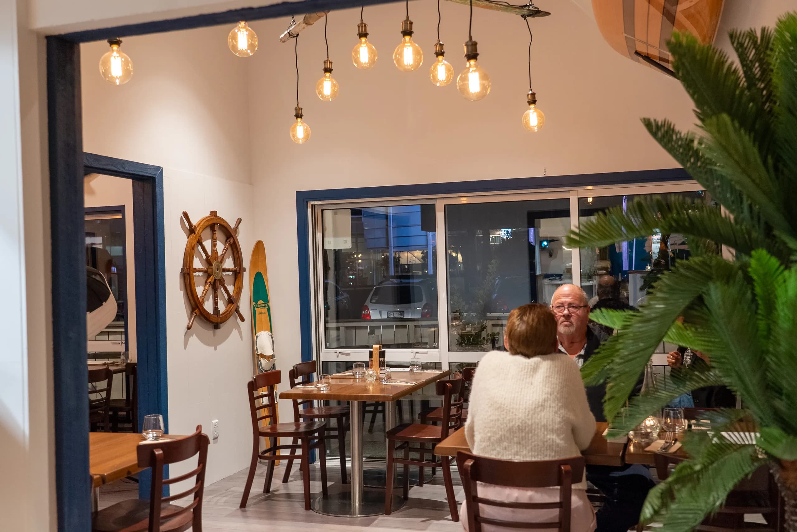 Wide view of Saltwood's nautical dining room with ship's wheel decor and warm lighting, Ferrymead.