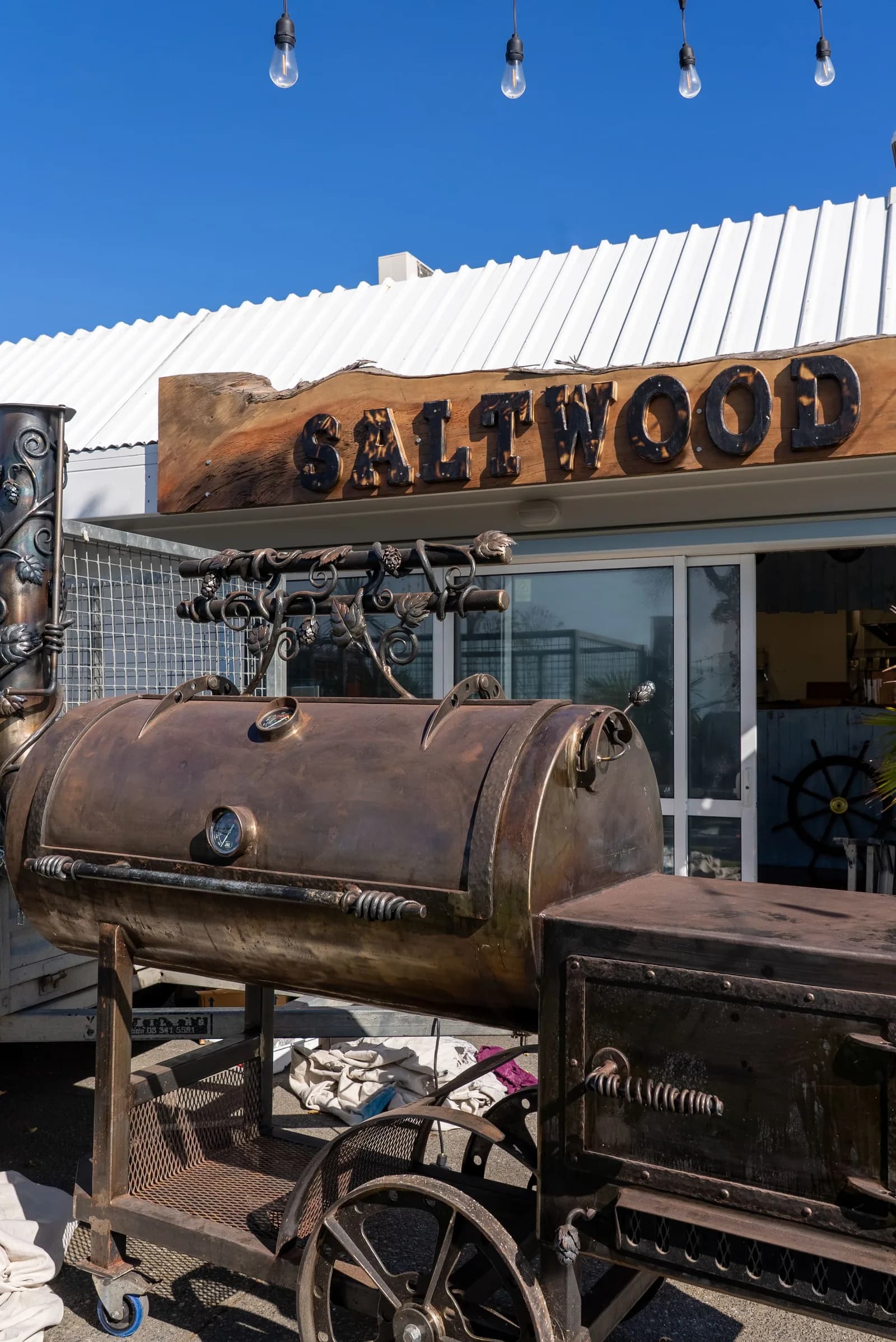 Saltwood custom offset smoker and wooden entrance sign at 13 Tidal View, Ferrymead.