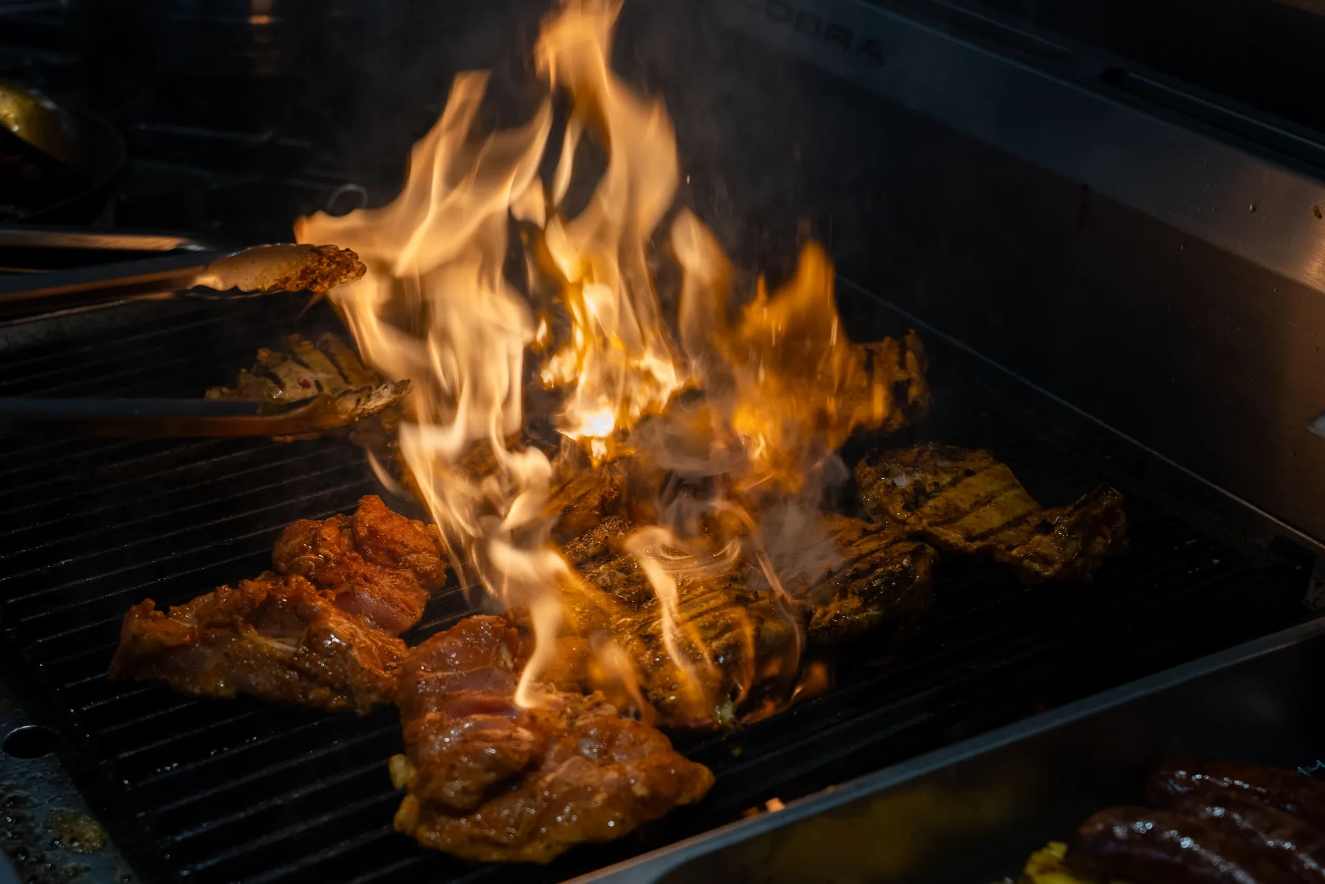 Wood-fired grill flames and glowing embers at Saltwood, Ferrymead, Christchurch.